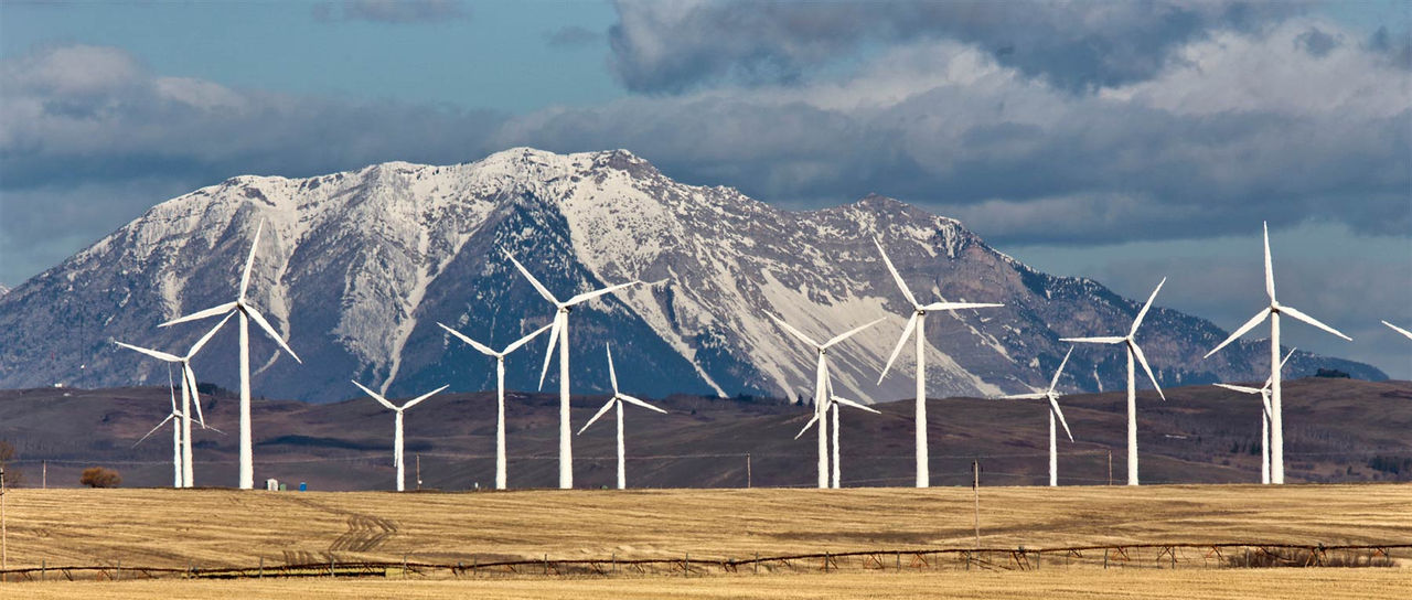 windmills-power-green-mountain-field-465937749.jpg